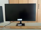 un écran d'ordinateur posé sur un bureau, à côté d'un autre écran d'ordinateur