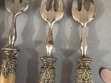 five forks and spoons that are on a table