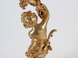 a gold colored candle holder with a statue on top of it