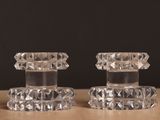 une paire de bougeoirs en verre transparent posés sur une table en bois