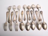 a lot of spoons and forks laid out on a table
