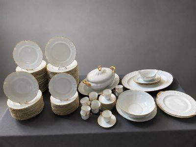 a lot of white and gold plates and bowls on a table