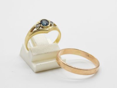 a close up of two gold rings on a white surface