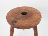 an old wooden stool with a hole in the middle of it