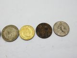 a row of five different coins sitting on top of a white surface