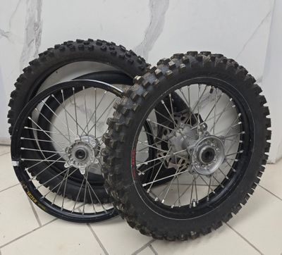 two dirt bikes that are sitting on a tile floor