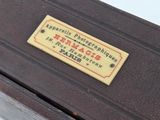 a brown suitcase with a label on it sitting on a table