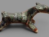 statue of a horse made of clay on a gray surface