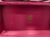 a close up of a pink box with a gold logo on it