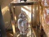 une table en verre sur laquelle se trouve un vase, à côté d'une chaise