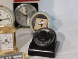 many different types of clocks sitting on a table