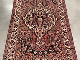 an antique persian rug with a large medallion design