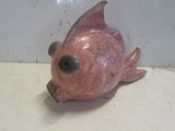 une figurine de poisson rose posée sur un comptoir