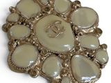 a picture of a brooch that is on a white surface