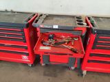 three red tool boxes with tools on top of them in a garage