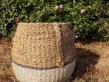 a straw hat sitting on the ground in front of a bush
