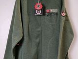 a green jacket hanging on a hanger on a wall