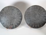 these are two plates with designs on them sitting on a white surface