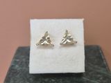 a pair of earrings sitting on top of a marble block