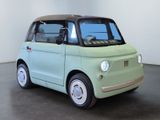 an image of a small green car in a white room