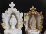 three figurines of a woman and a man in a shell