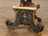 a statue of a person standing on top of a stool