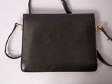 a black purse sitting on top of a white table