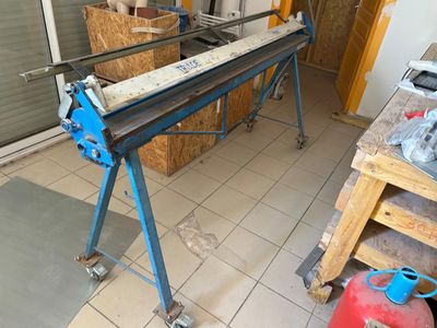 une photo d'un établi dans un garage avec de nombreux outils