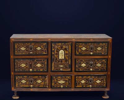 an antique chest of drawers with a decorative design on the front