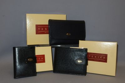 trois portefeuilles en cuir noir posés les uns sur les autres sur une table