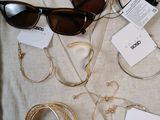 several pairs of sunglasses, bracelets, and necklaces sitting on a table