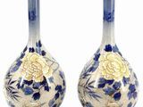 pair of blue and white vases with gold accents on stands