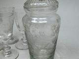 a glass jar with a lid and a glass goblet next to it