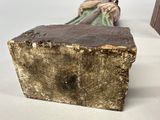 a small statue of a person sitting on a bench