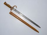 an old sword with a wooden handle on a white surface