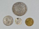 four different types of silver and gold coins on a white surface