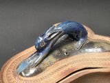a blue and brown sculpture of a lizard on top of a wooden box
