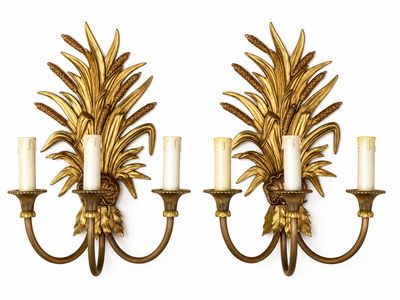 paire d'appliques murales dorées avec des bougies blanches et des feuilles dorées