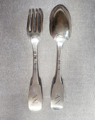 deux cuillères et une fourchette en argent sur une table