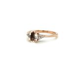a close up of a ring with a brown diamond and two white diamonds