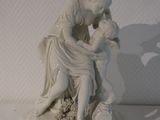 une statue représentant une femme et un enfant assis sur une table