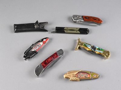 many different types of pocket knives on a table