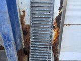 a metal grate on the ground next to a door