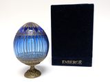 a blue glass egg sitting next to a black box