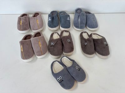 Plusieurs paires de chaussons sont alignées sur une surface blanche