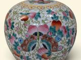 a colorful vase with flowers on it on a white surface