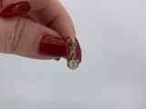 woman ' s hand with red manicured nails holding a gold and diamond ring