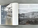 an open book with a black and white photo of a train station
