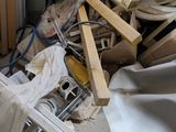 a pile of wood sitting in a room with a lot of clutter