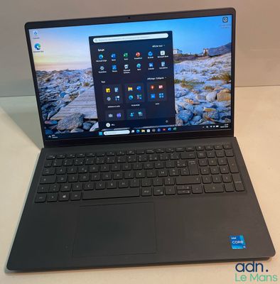 un ordinateur portable ouvert posé sur une table, à côté d'un clavier